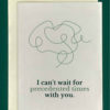Close-up of a white greeting card on top of a cream-colored envelope, all on a forest background. The card features a drawing of a squiggly messy line and words that read "I can't wait for precedented times with you."