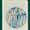 Close up of a white greeting card on top of a cream-colored envelope, all on a forest background. The greeting card features an simple drawn image of Earth with the words, "Love Your Mother" in white taking up most of the Earth circle.