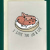Close-up of a white greeting card on top of a cream-colored envelope, all on a forest background. The card features a drawing of Smoked salmon, capers, and cream cheese on a fresh bagel. Underneath read the words, "I Love you Lox and Lox"